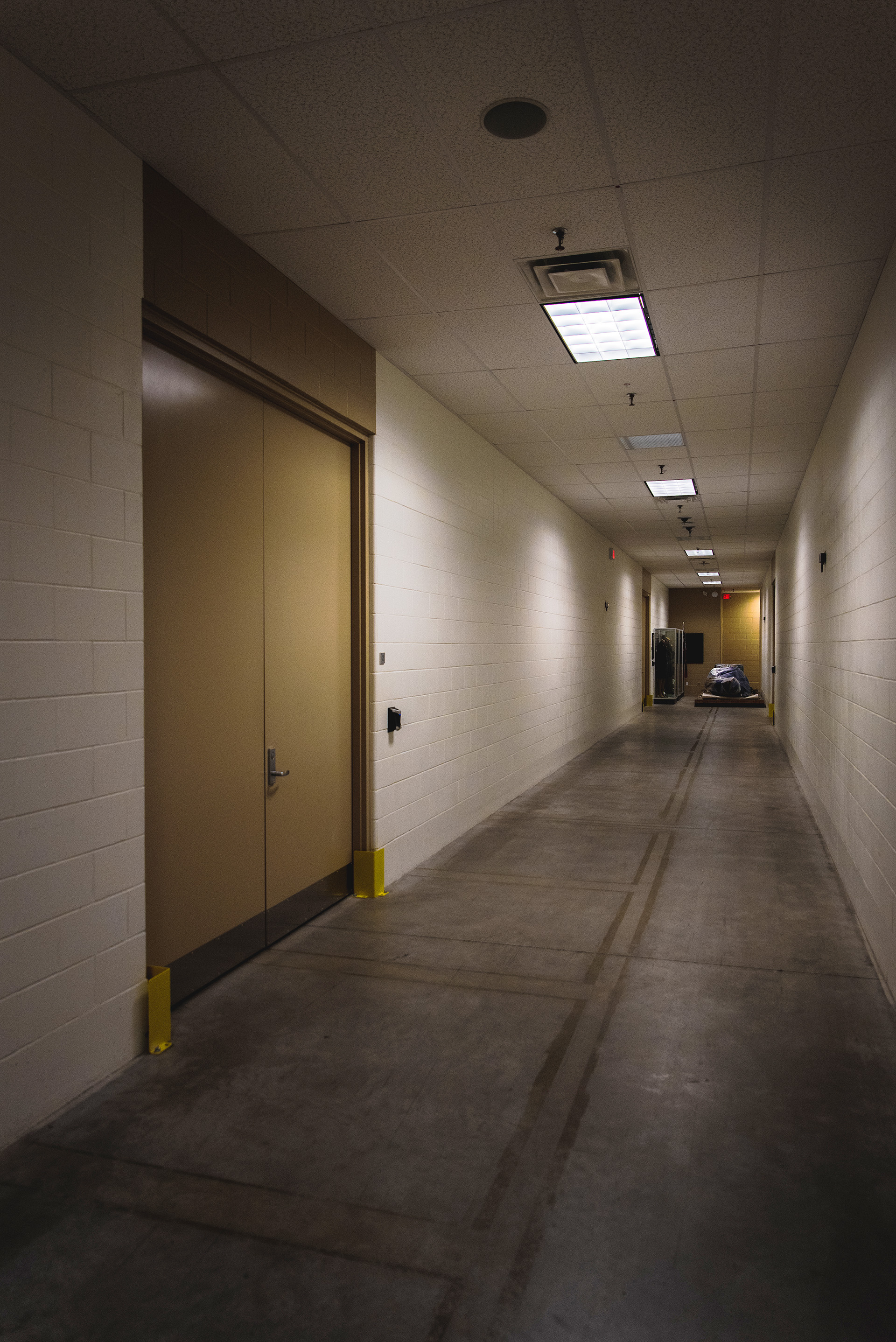 long, dimly lit hallway with cement floors.
