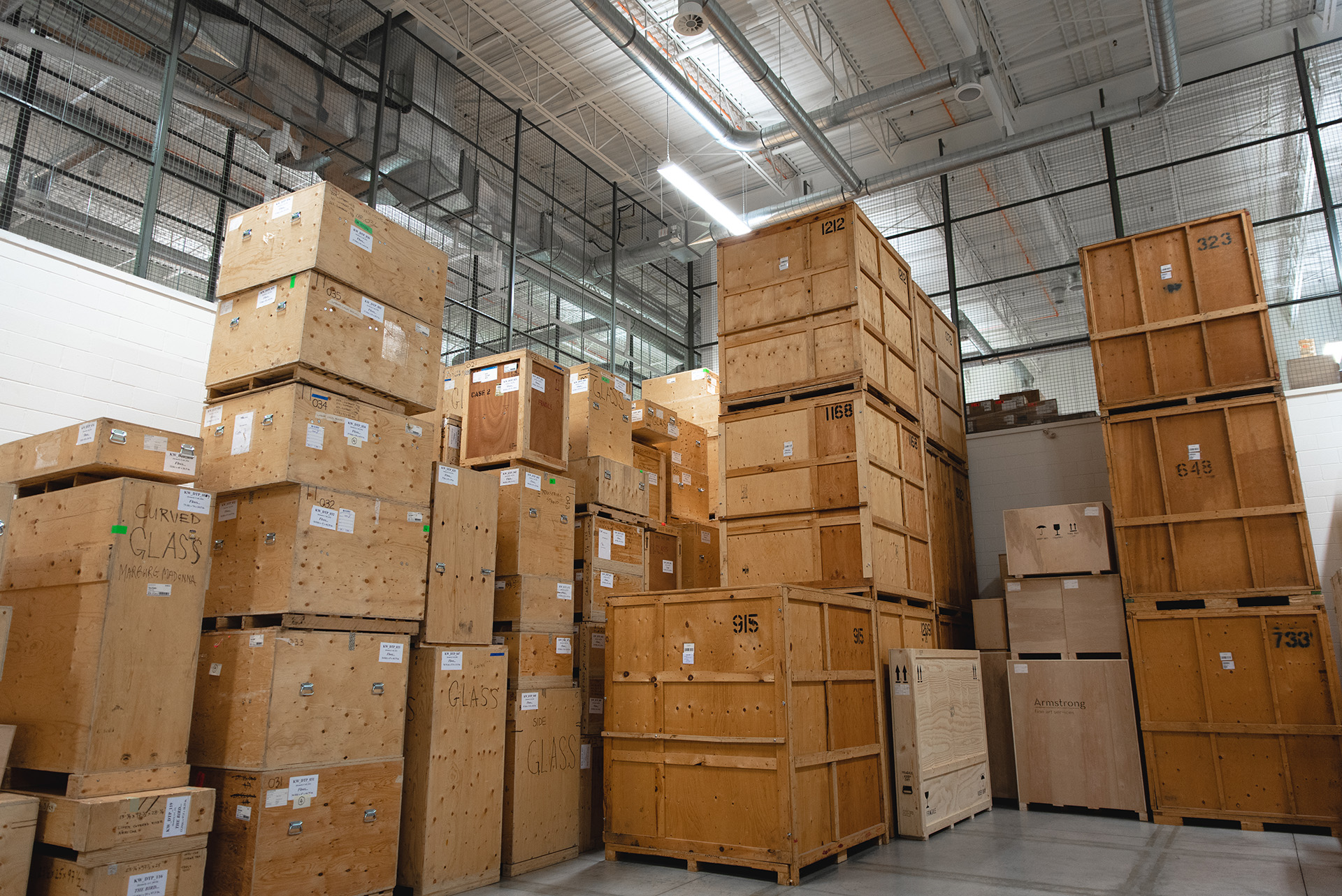 stacks of large wooden crates inside of a warehouse.